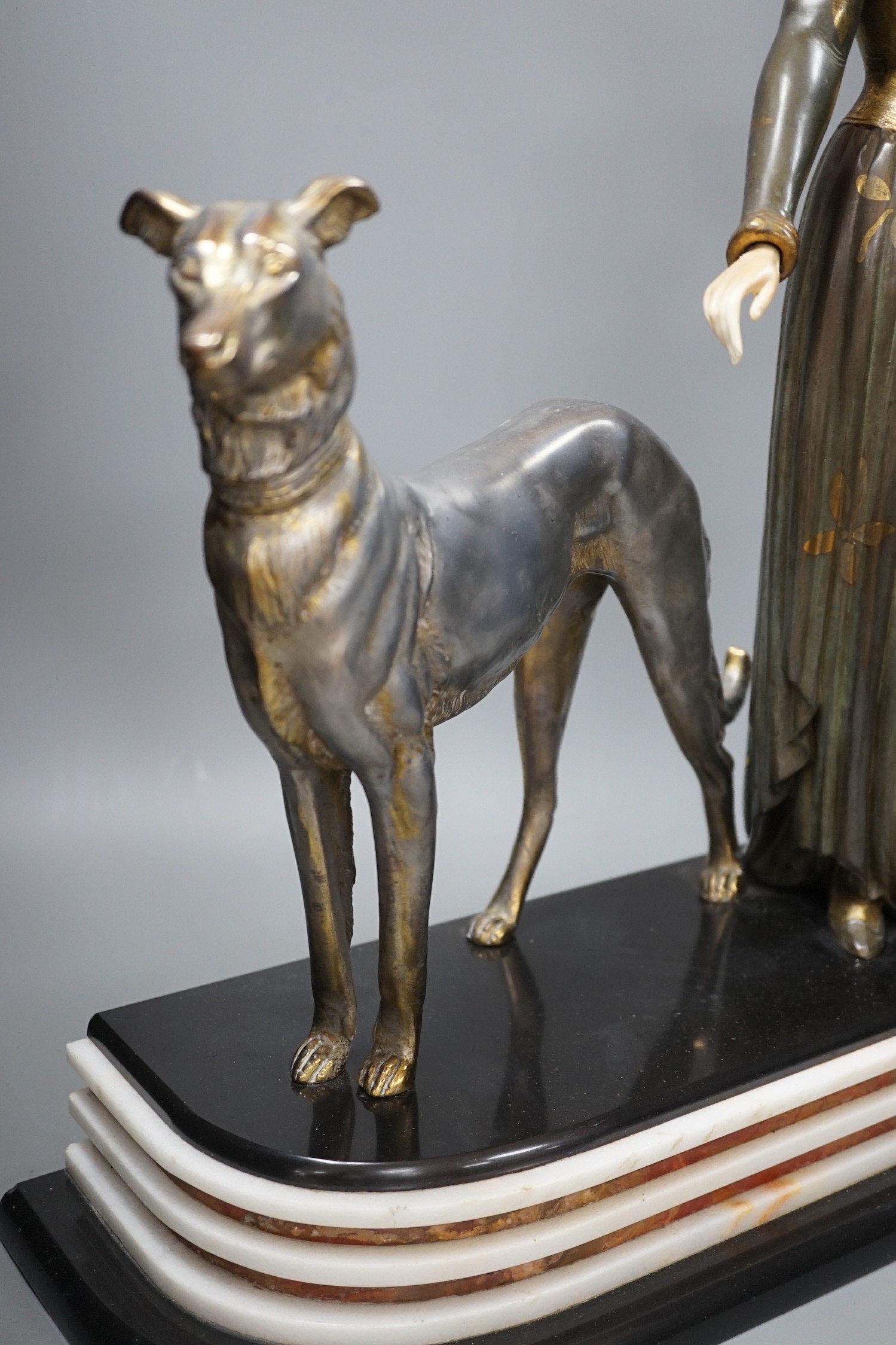 An Art Deco spelter and composition figure of a lady and a hound, signed Menneville, 57 cms high